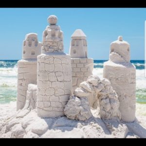 Foto de castillo de arena con esculturas de arena en la playa