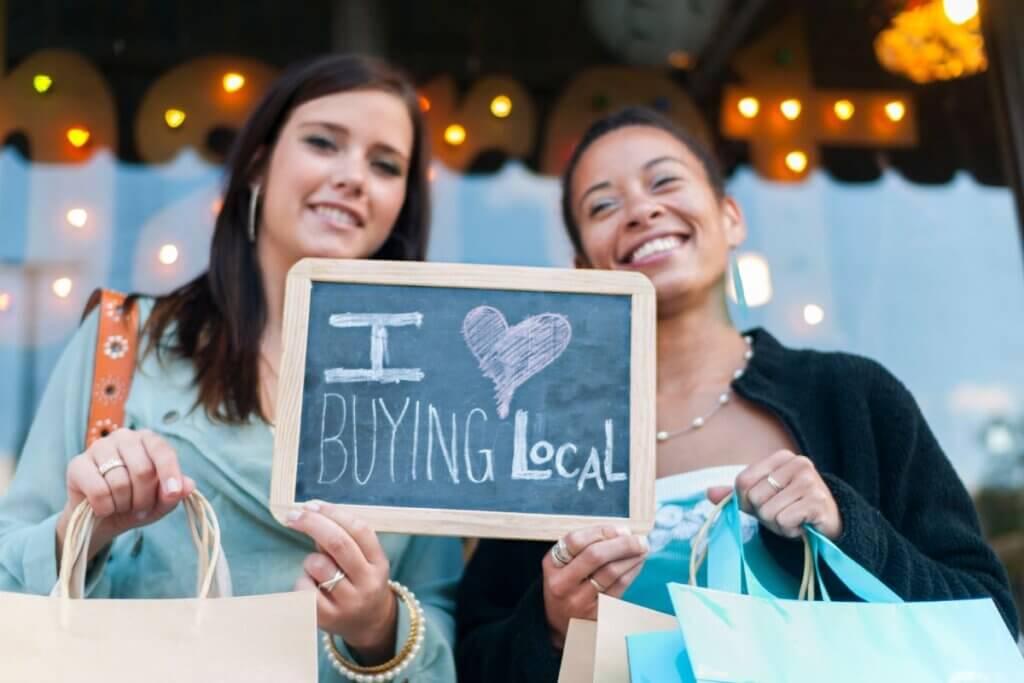 Two women holding I Love Buying Local sign